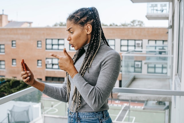 Une femme passe un appel vidéo avec une personne figurant dans ses messages instantanés.