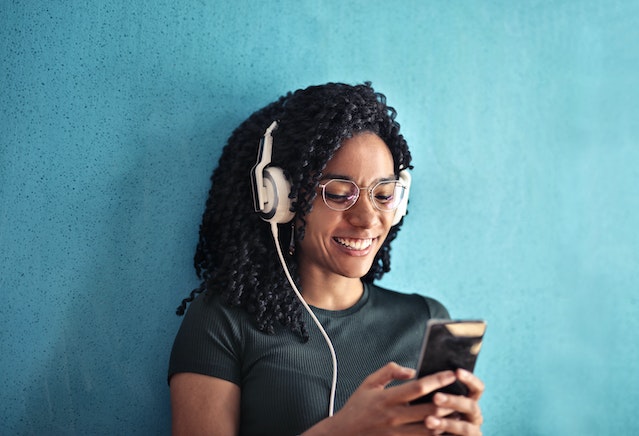 Woman smiling after seeing an Instagram post with trendy background music.