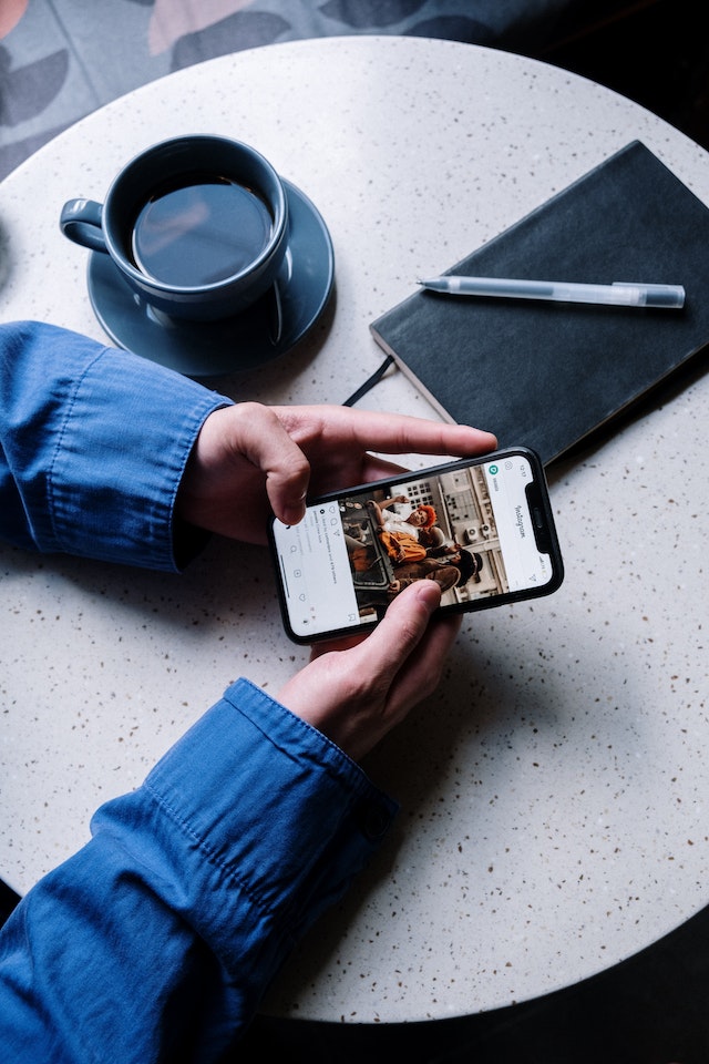 pexels-cottonbro-studio-5053739 | Path Social Un creatore di contenuti valuta se incrementare un post su Instagram.