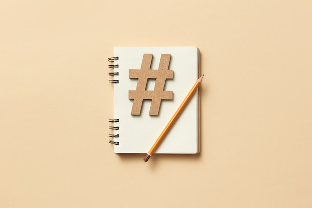 Un hashtag y un lápiz en un bloc de notas que representan las redes de afiliación en una cuenta Instagram .