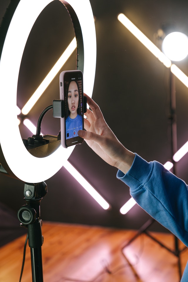 A woman records content on her ring light for her Instagram ad.
