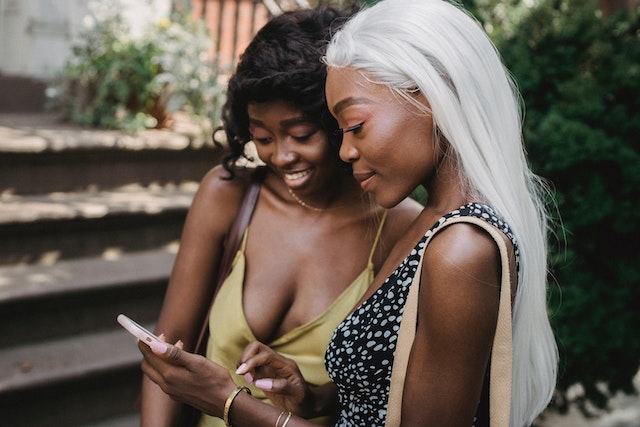 A woman telling her friend about a new brand she discovered online. This is social proof through word-of-mouth marketing.