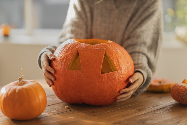pexels-monstera-production-5634784 | Path Social Mulher a esculpir o seu Jack O' Lantern para o seu Halloween de outono Instagram post.