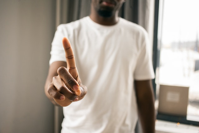 Homem que não mostra qualquer sinal com o dedo indicador.