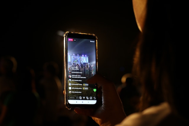 A woman is reading live chats on a live video session on her phone. 