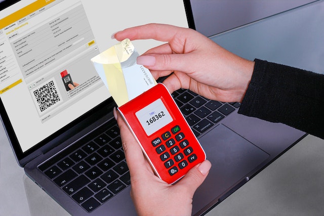 Man holding a POS device and a VISA card.