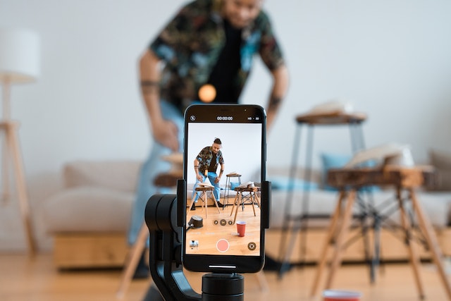 Man shooting a vertical video on his phone for an Instagram Reel.