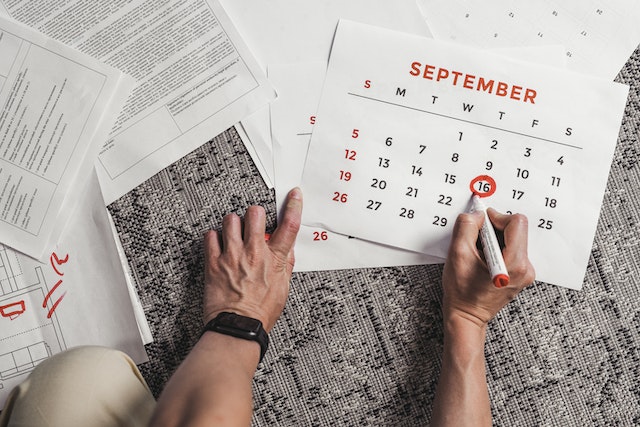 Person using a calendar to keep track of their posting schedule.