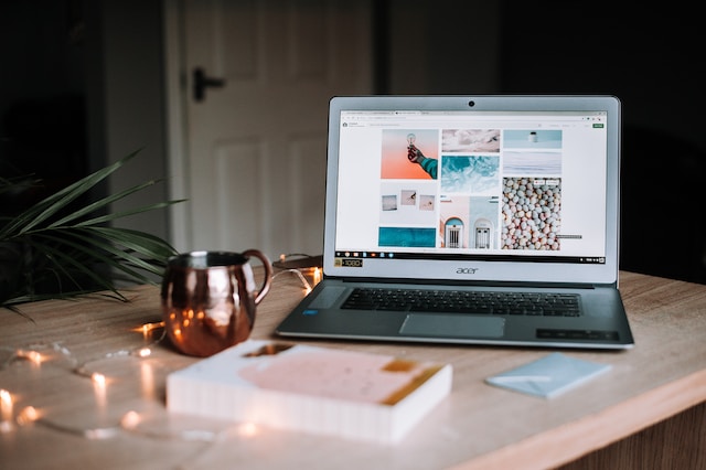 A laptop sits on a desk with an Instagram profile page on the screen.