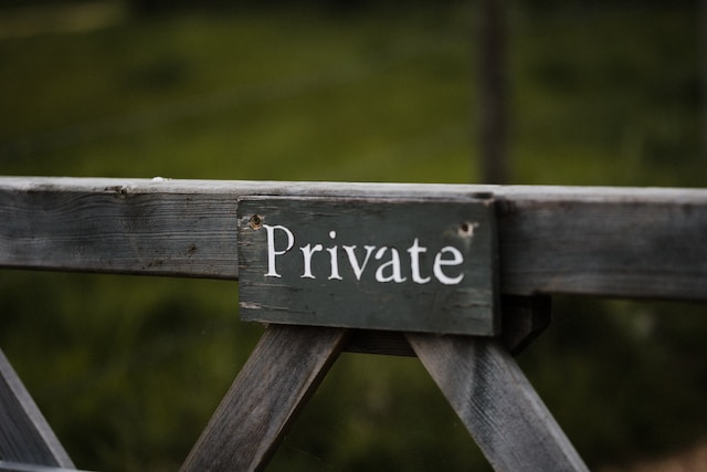 Een grijs houten bord met de tekst &quot;Private&quot;.