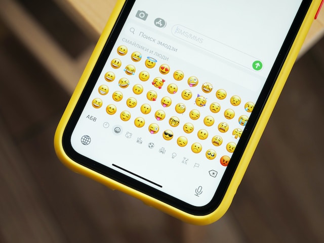 Quelqu'un qui tape un message texte en utilisant le clavier emoji.