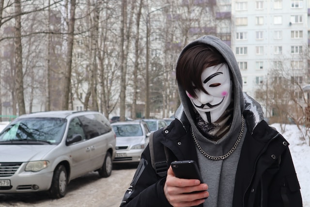 A user putting on a mask while checking out his phone. 