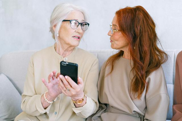 Een oudere vrouw leert internettaal van haar dochter.