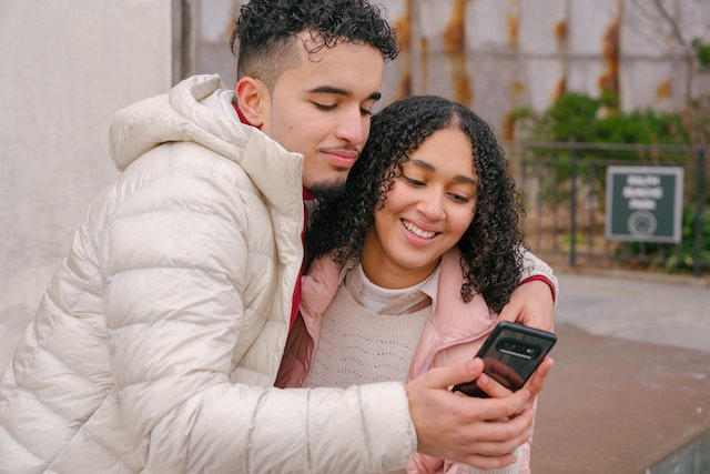 A couple happily discussing how to include each other on their Instagram bios