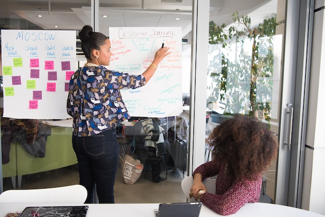 Zwei Frauen in einem gläsernen Büro besprechen Strategien Instagram .