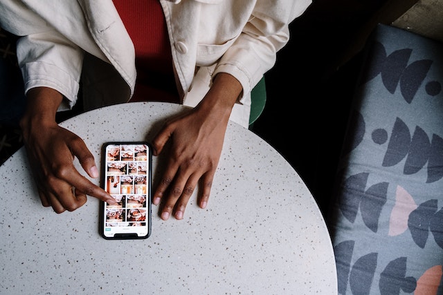 카페의 테이블에 앉아 자신의 Instagram 프로필을 확인하는 사용자.