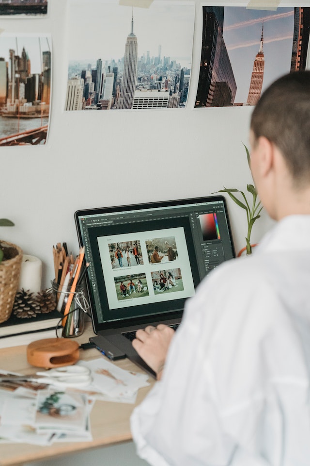 An influencer editing photographs on a laptop. 