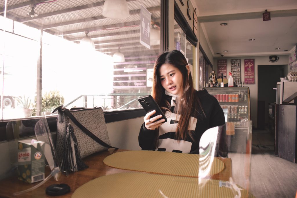 Eine Inhaltserstellerin teilt ihr neu aufgenommenes Reel auf ihrem Instagram Konto, während sie in einem Café sitzt.