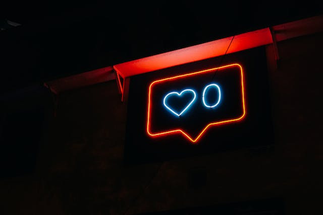 Een neonbord met het hartsymbool en het cijfer nul ernaast, wat nul likes aangeeft.