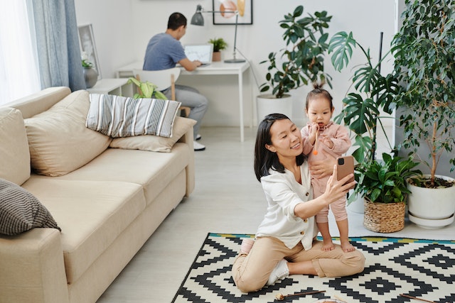 An influencer recording an Instagram story with her child for her account.