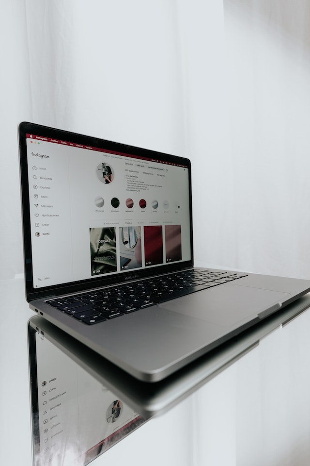 Een laptop op een tafel met een reflectie van een profiel op Instagram .