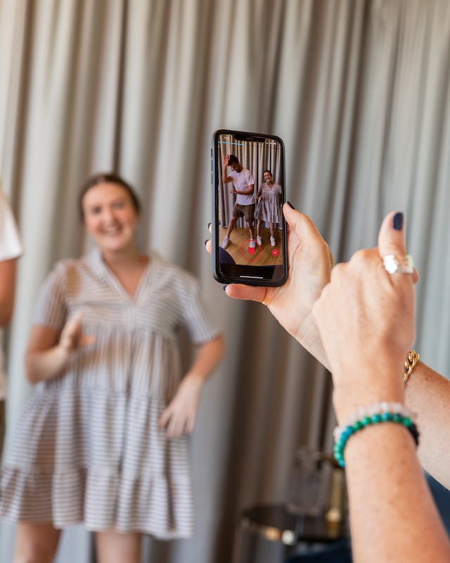 Femme capturant un moment de danse joyeuse sur l'appareil photo.