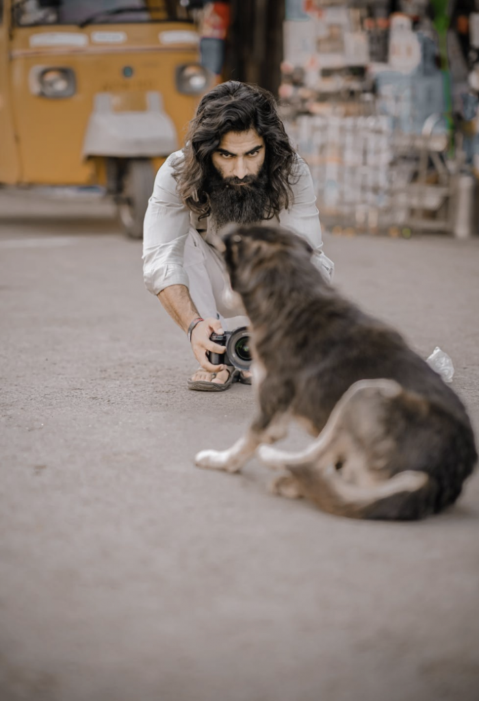 Um criador de conteúdos tira uma fotografia do seu cão no chão.