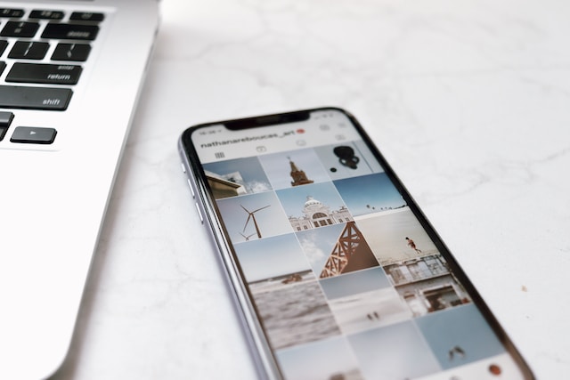 Image d'un smartphone posé sur une table blanche et affichant une collection de contenus Instagram .