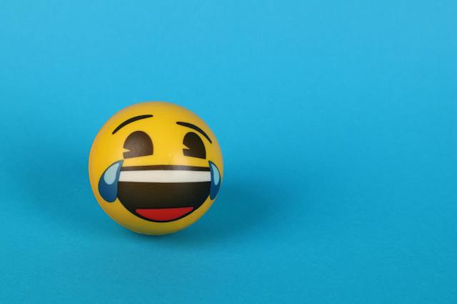 A laughing and crying emoji against a blue background.