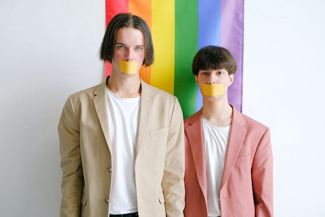Two members of the LGBTQIA+ community with tape over their mouths after they were discriminated against.