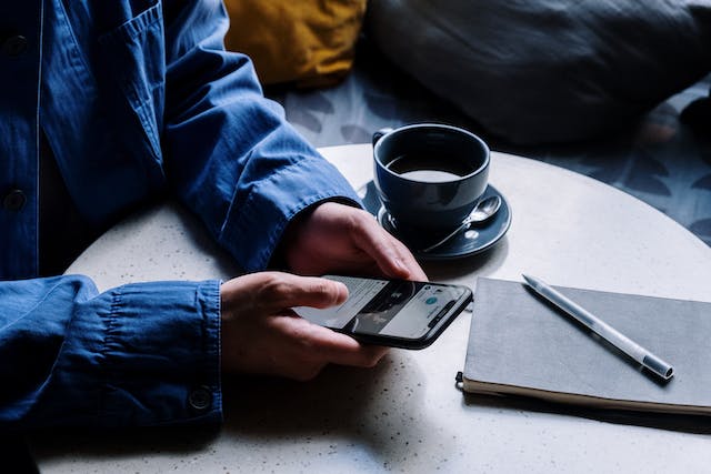 Une personne assise devant son téléphone qui regarde un message Instagram qu'elle envisage d'annuler.