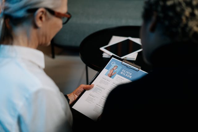 Una mujer hojeando la portada del dossier de prensa de alguien.