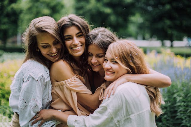 A group of girlfriends smiling and hugging.