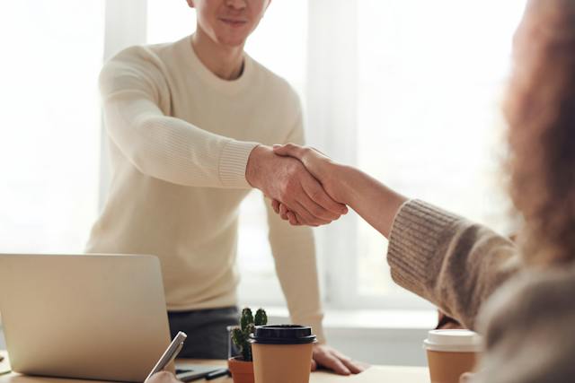 Un hombre y una mujer se dan la mano.