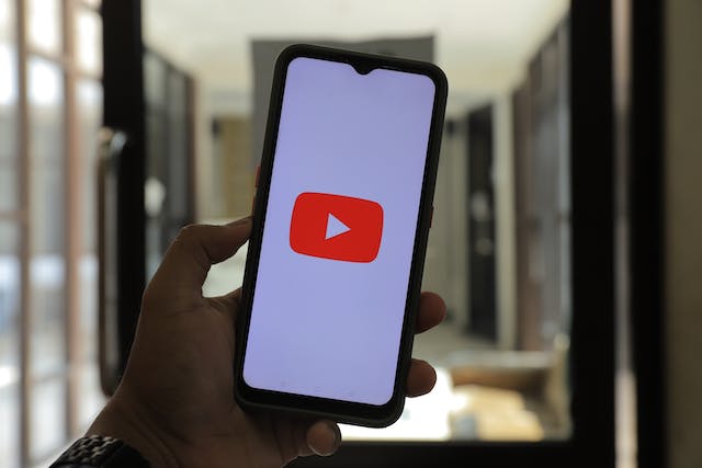 Un bărbat deschide YouTube pe telefonul său.