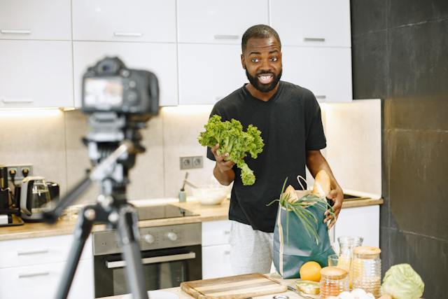 Un uomo sta registrando un video su YouTube in cucina.