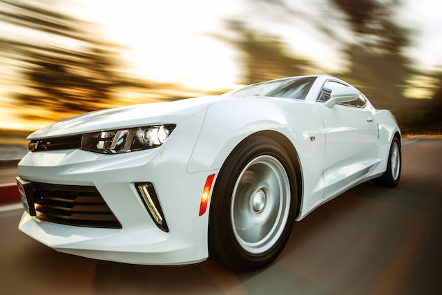 Een witte Chevrolet Camaro raast over de snelweg.