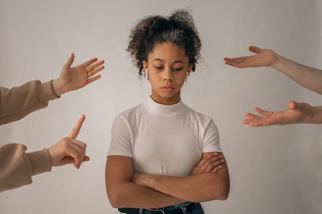 Una ragazza che si sente turbata perché tante persone le lanciano commenti negativi.