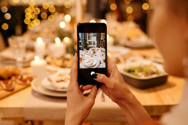 Eine Frau macht ein Foto von ihrem köstlichen Weihnachtsessen.