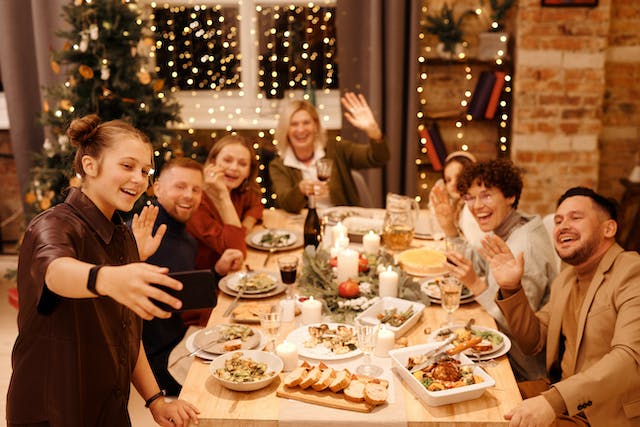 Een gezin viert Kerstmis door een selfie te nemen tijdens het diner.