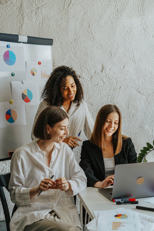 Trois influenceurs Instagram sur un canapé avec un ordinateur portable pour collaborer sur un projet.