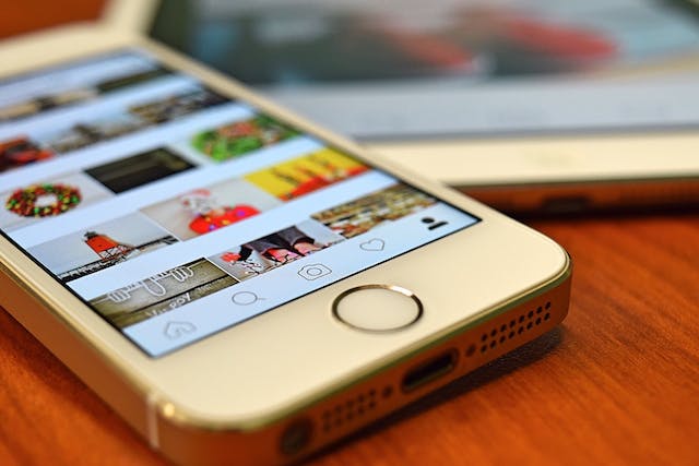 Uma imagem de um iPhone 5 prateado com uma coleção de Instagram bobinas.