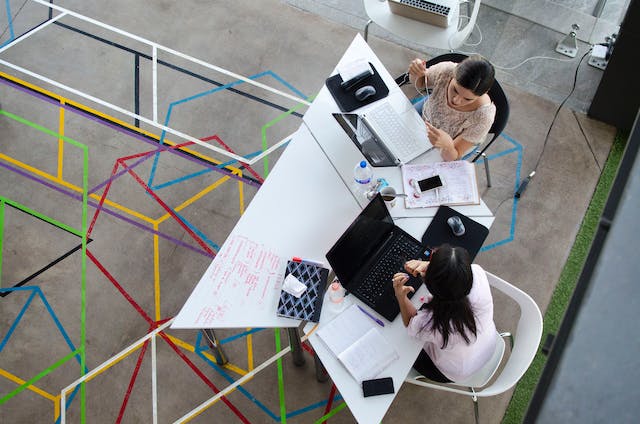 Aerial shot of two women using Instagram on their laptops. 