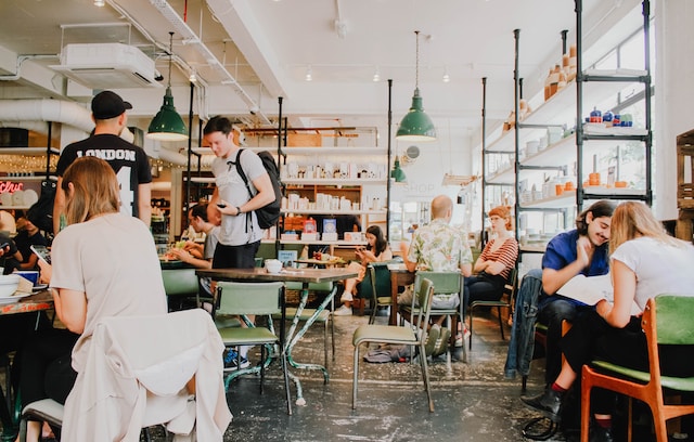 Une photo de personnes mangeant à l'intérieur d'une cafétéria.