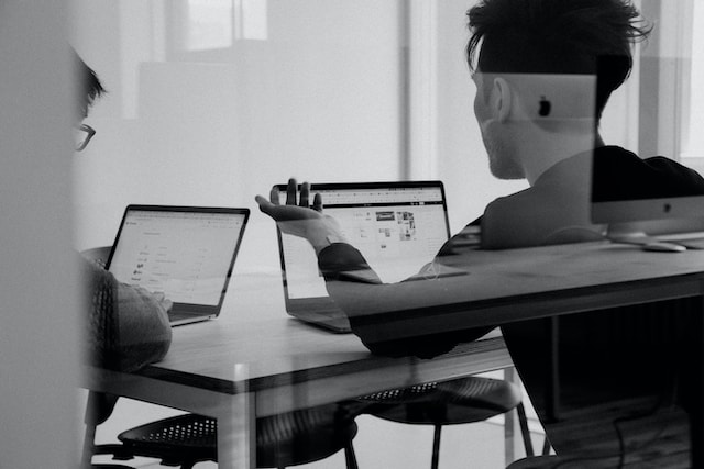 Dos personas discuten en una reunión estrategias de marketing en redes sociales para pequeñas empresas. 