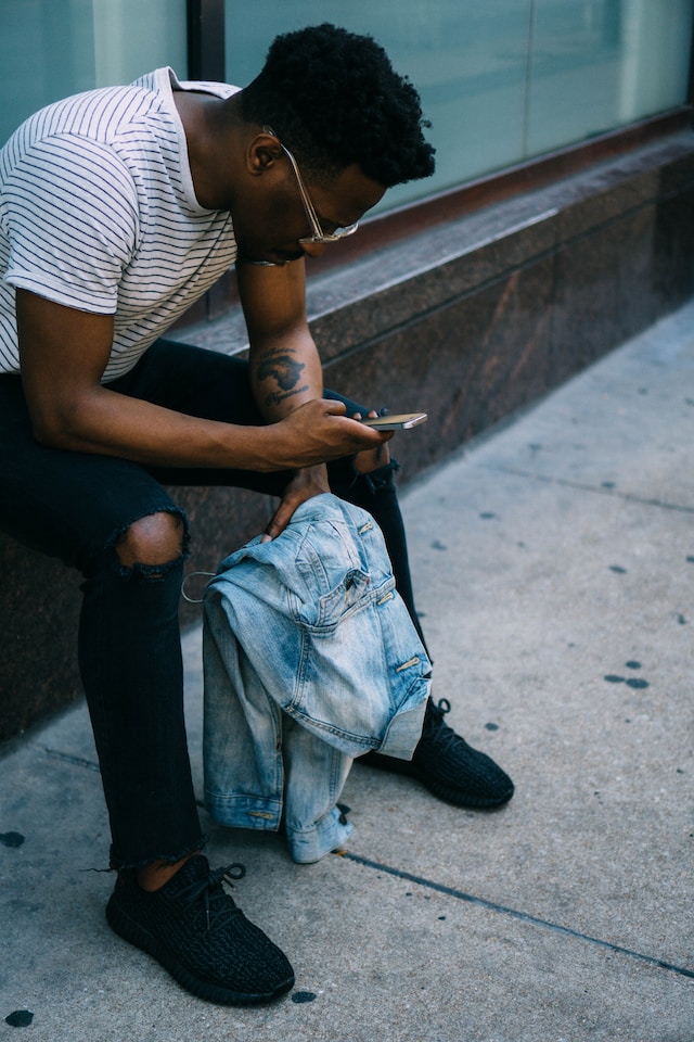 A man checking his phone to see if he is blocked on Instagram.