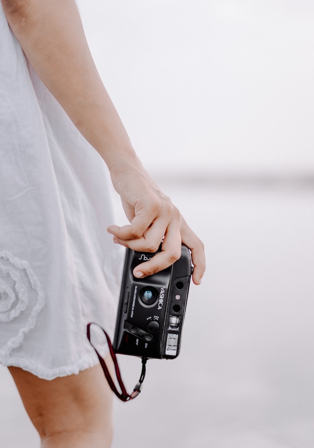 Une femme tenant un appareil photo.