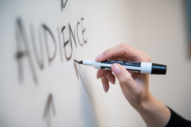 Uma pessoa escreve com um marcador de apagar a seco num quadro.