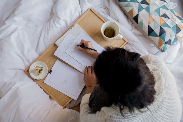 A woman is writing notes about her plans for her Instagram Business account.