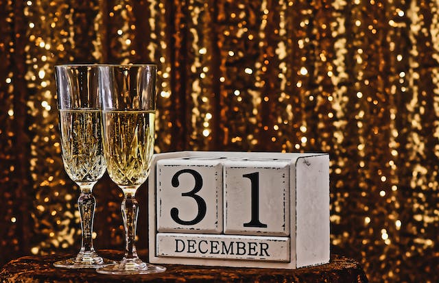 Glasses of champagne and blocks that say “31 December” on a table at a New Year’s Eve party.